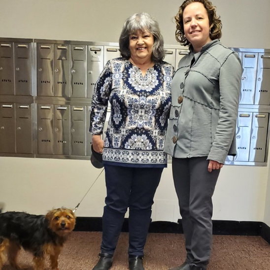 two women in apartment building with little dog