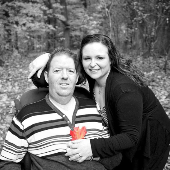 Man and woman posing for photo man in wheelchair