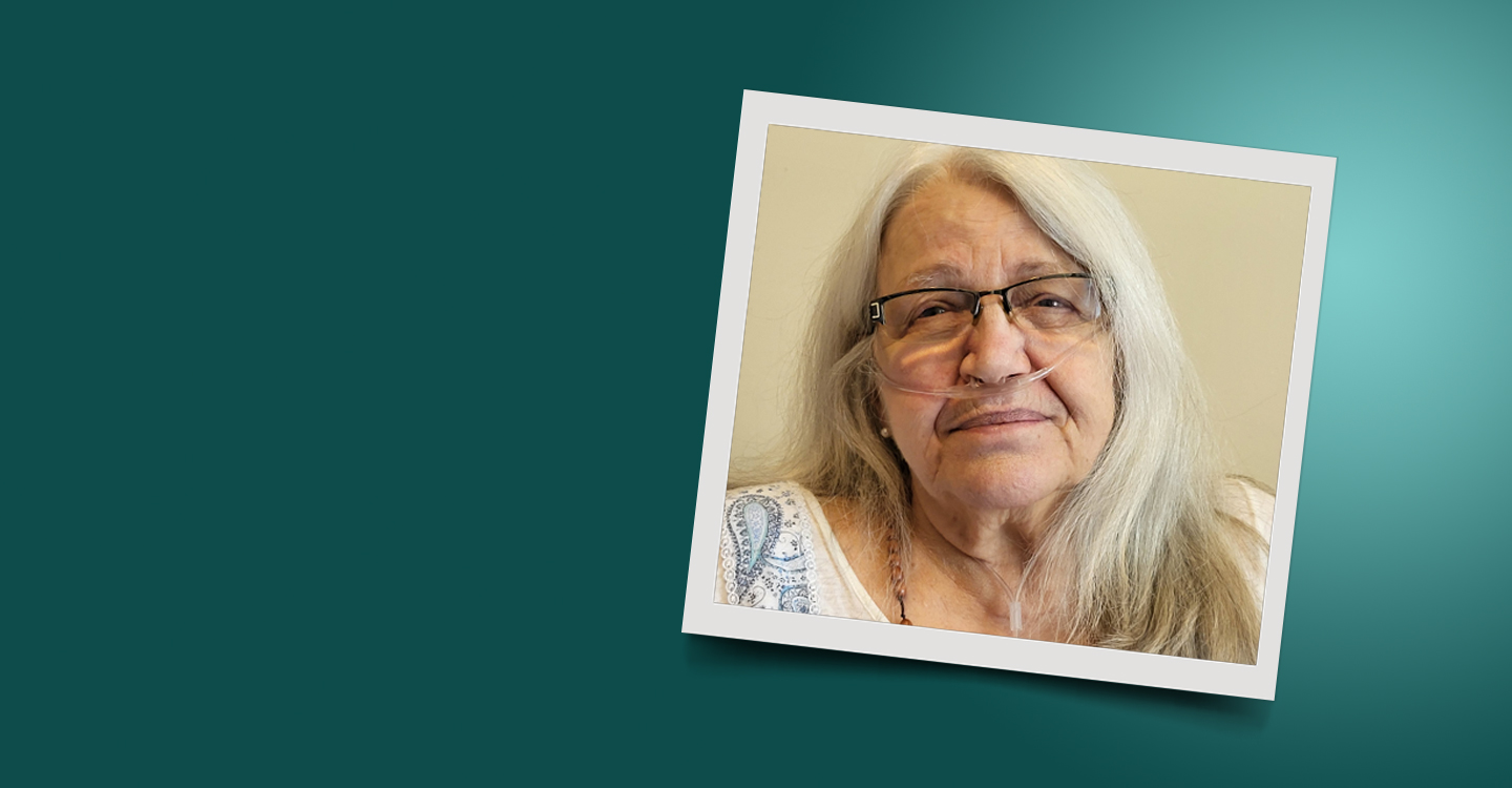 Senior woman with long grey hair and wearing oxygen