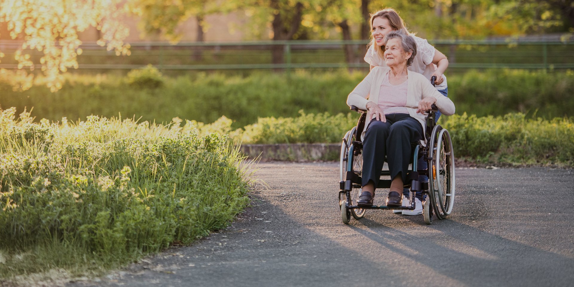 woman pushing patient in wheelchair
