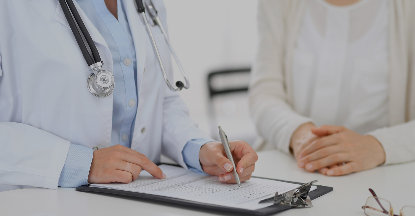 A doctor writing on a clipboard.