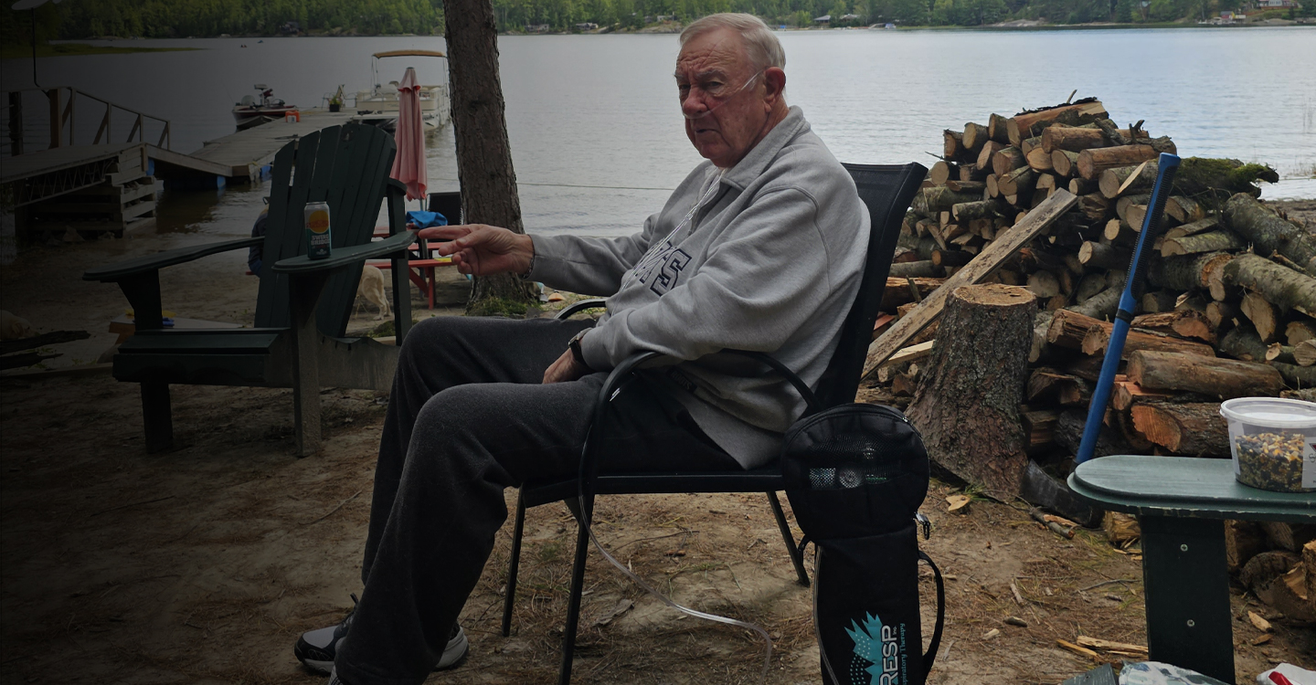 man sitting in chair outdoors wearing oxygen