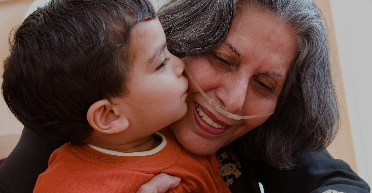 Grandson kissing grandma wearing oxygen